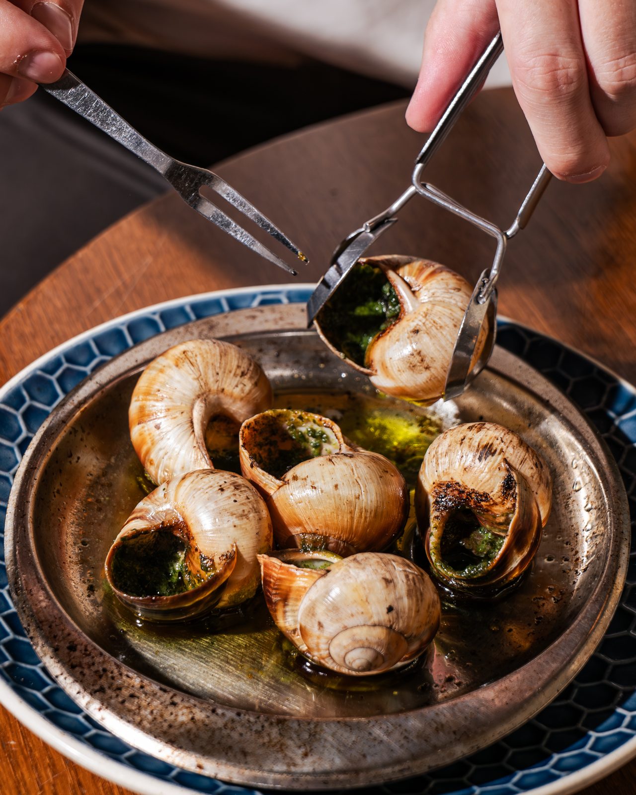 Escargots servis dans leur plat avec pince et fourchette à la brasserie Saint André