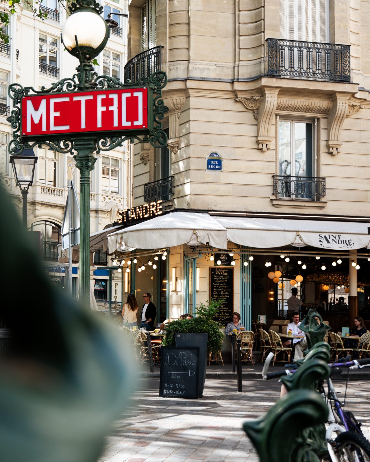 Façade et terrasse de la brasserie Saint André près d'une entrée de métro parisien