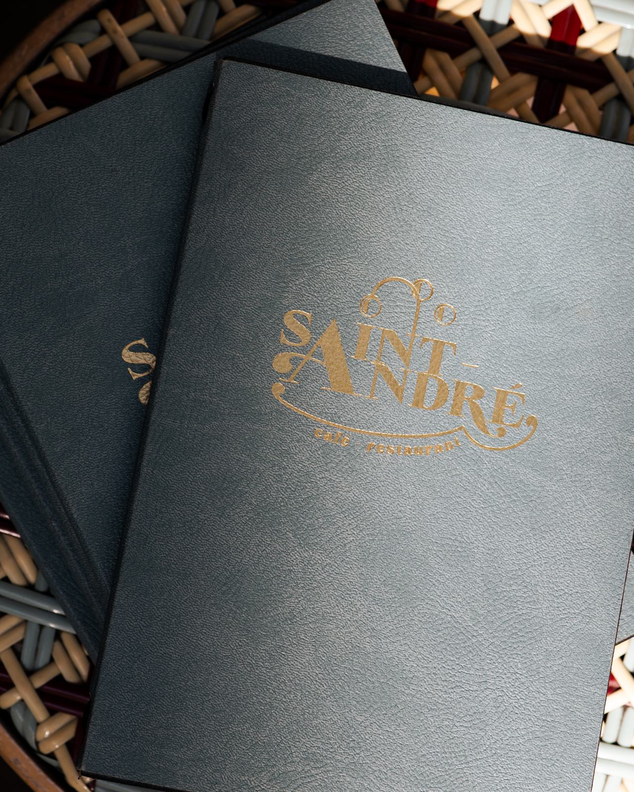 Cartes de menu bleu nuit de la brasserie Saint André avec logo doré