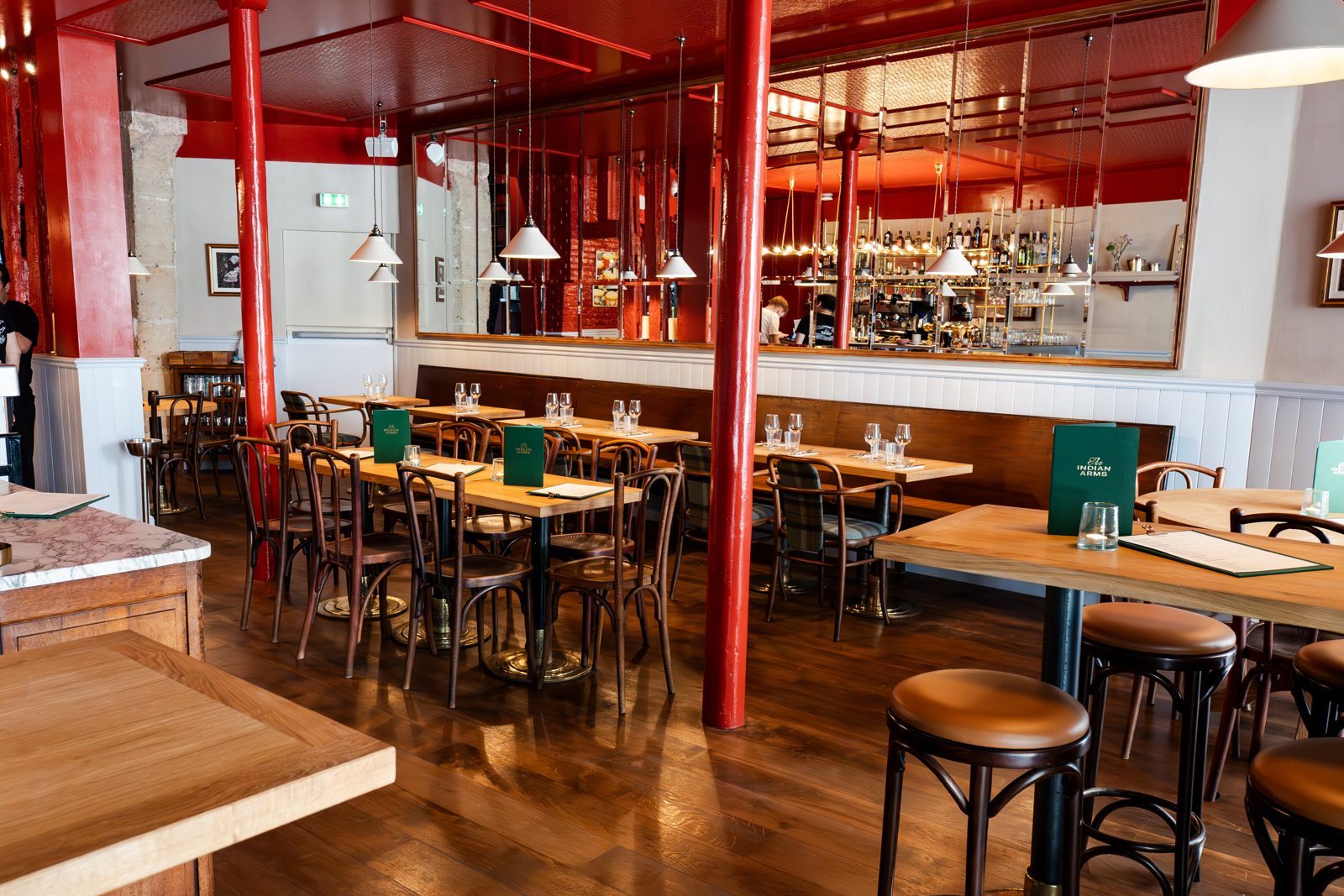 Salle de The Indian Arms prête pour l'ouverture avec tables en bois et cuisine ouverte